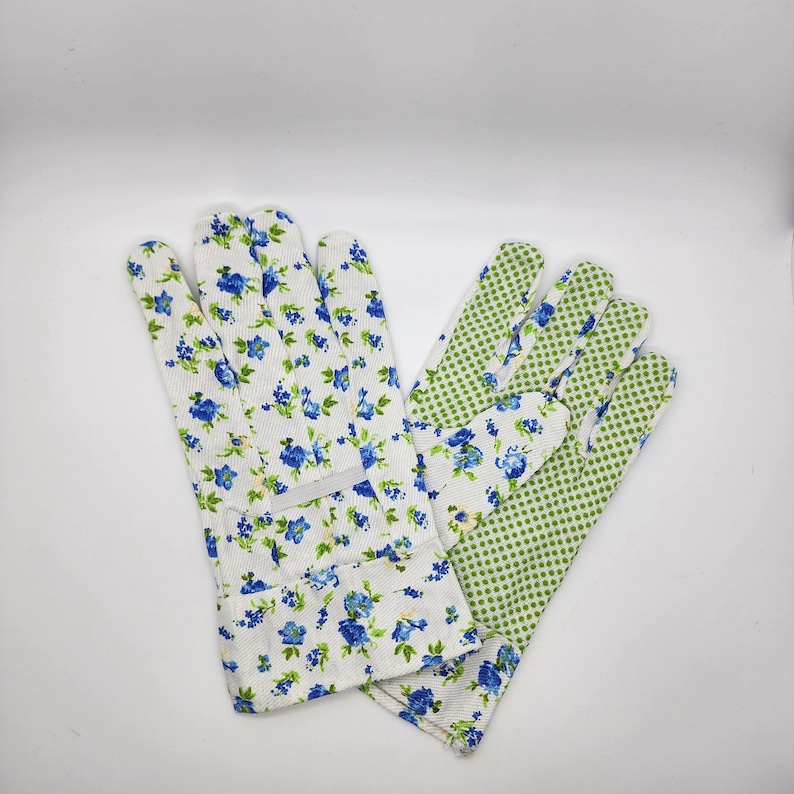 May include: A pair of gardening gloves with a floral print. One glove is white with blue flowers and green leaves, the other is green with white polka dots.