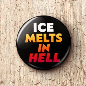 May include: A black button with the text "ICE MELTS IN HELL" in white, yellow, and red. The button is round and glossy, set against a light brown, textured wooden surface.