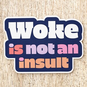 May include: A die-cut sticker with a dark blue background featuring the white text Woke on the top line, the pink and light purple text is not an on the second line, and the peach-colored text insult on the bottom line with a white border.