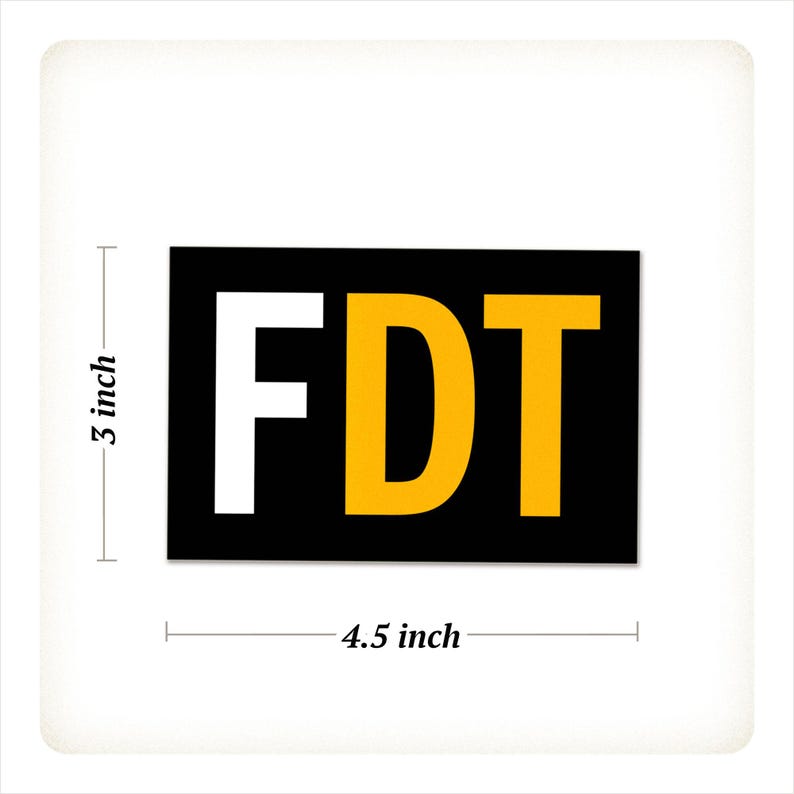 Może przedstawiać: Prostokątna naklejka z literami "FDT" pogrubioną czcionką. Litera "F" jest biała, "D" jest ż&oacute;łta, a "T" jest ż&oacute;łta. Tło jest czarne. Naklejka ma 11,4 cm szerokości i 7,6 cm wysokości.