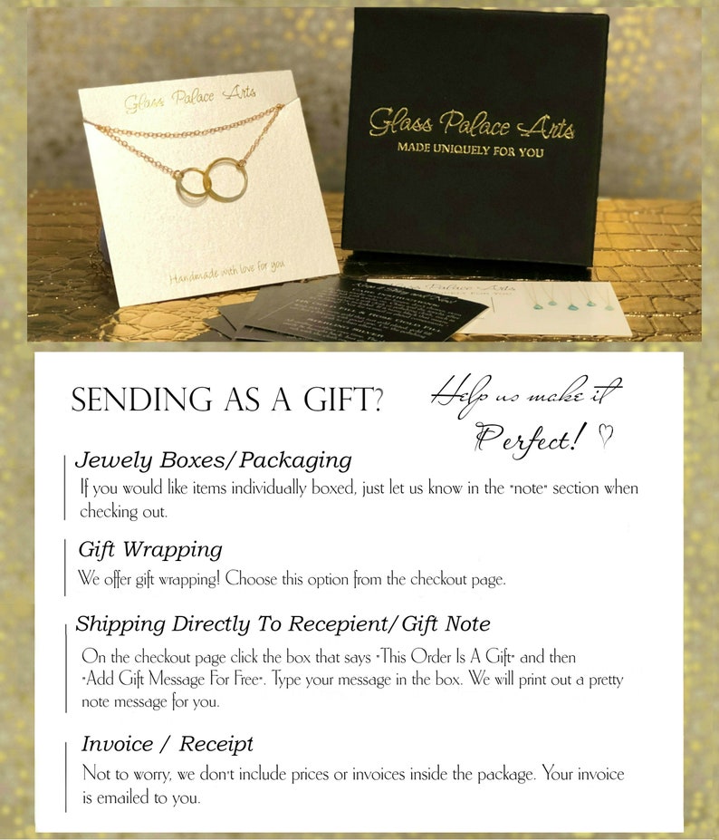 May include: A gold necklace with two interlocking circles, displayed on a white card with the text "Glass Palace Arts" and "Handmade with love for you". The card is sitting on a black box with the text "Glass Palace Arts" and "Made Uniquely For You".