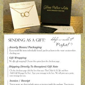 May include: A gold necklace with two interlocking circles, displayed on a white card with the text "Glass Palace Arts" and "Handmade with love for you". The card is sitting on a black box with the text "Glass Palace Arts" and "Made Uniquely For You".
