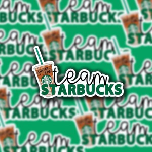 May include: A sticker with a green background and white text that says "team starbucks". The sticker also features a cartoon image of a cup of iced coffee with a straw.