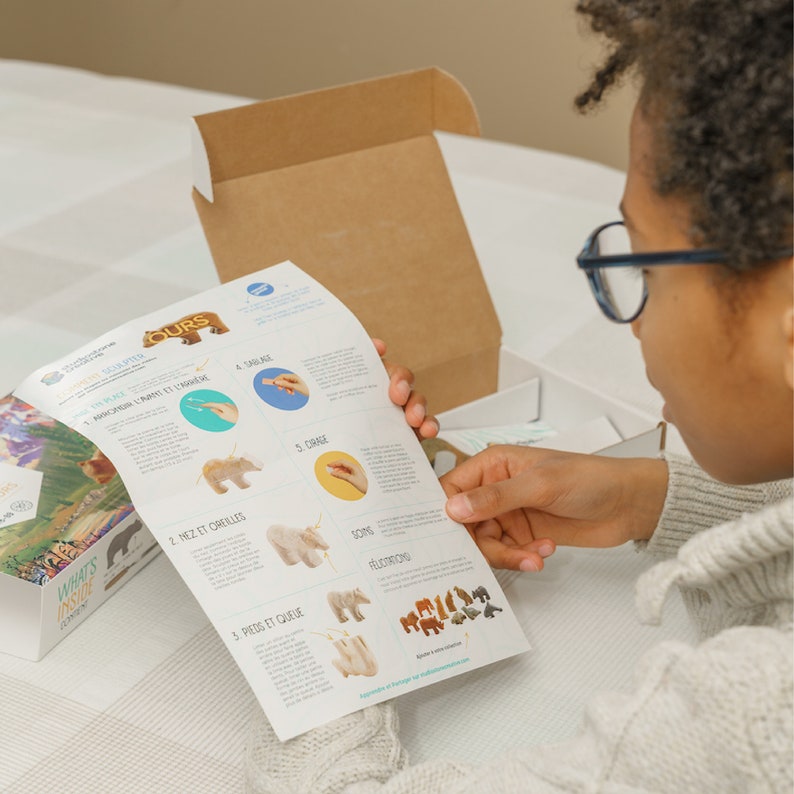 Boy looking at craft kit instructions for soapstone bear