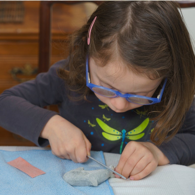 Girl carving soapstone orca