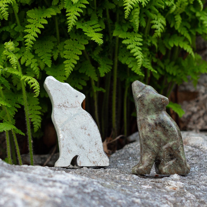 Soapstone wolf sculpture on rock in nature