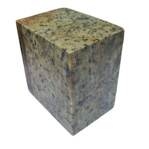 Può includere: Un blocco di pietra rettangolare con bordi superiori arrotondati. La pietra presenta un motivo screziato di verde, marrone e nero. Il blocco è una forma geometrica solida, probabilmente per uso decorativo o funzionale.