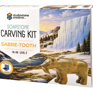 May include: A soapstone carving kit for a sabre-tooth tiger. The box features a diorama of a snowy landscape with a carved soapstone sabre-tooth tiger. The kit is labeled "Soapstone Carving Kit Sabre-Tooth Level 2".