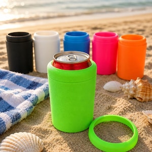 Puede incluir: Una colecci&oacute;n de enfriadores de latas cil&iacute;ndricos en varios colores s&oacute;lidos, incluyendo negro, blanco, azul, rosa, naranja y un verde lima brillante. Un enfriador verde lima sostiene una lata de metal, con un anillo a juego.