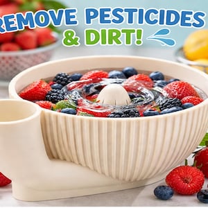 Op de afbeelding: Een beige fruitschaal met de tekst "REMOVE PESTICIDES & DIRT!". De kom is gevuld met water, aardbeien, blauwe bessen en bramen. Een wit cilindrisch object bevindt zich in het midden van de kom.
