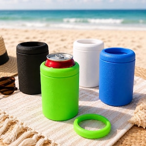 Puede incluir: Un conjunto de cuatro enfriadores de latas cil&iacute;ndricos en negro, blanco, azul y verde lima. Un enfriador verde lima contiene una lata de metal, y un anillo circular a juego de color verde lima se encuentra separado en la superficie.