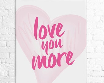 May include: A white poster with a pink heart shape and the text "love you more" in pink lettering.
