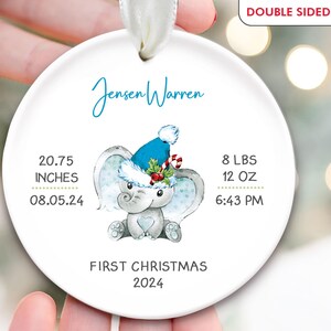 Pu&ograve; includere: Addobbo natalizio in ceramica bianca con un elefante blu e bianco che indossa un cappello di Babbo Natale. L'addobbo riporta le scritte "Jensen Warren", "Primo Natale 2024", "20,75 pollici", "08.05.24", "8 libbre 12 once", e "18:43".