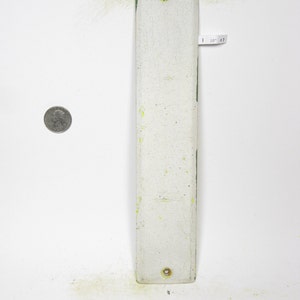 Op de afbeelding: Een wit rechthoekig metalen bord met groene randen en twee kleine messing schroeven. Het bord is leeg en heeft een versleten, verweerde uitstraling.