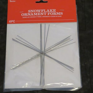 May include: A package of snowflake ornament forms. The package has a red header with the words "SNOWFLAKE ORNAMENT FORMS" in white. The package contains six silver wire snowflake forms.