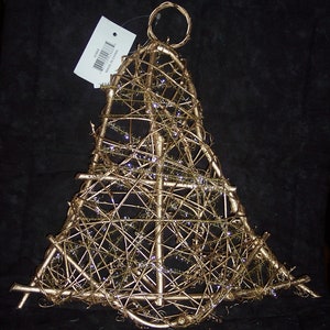 May include: A gold-colored, triangular-shaped decorative item made of interwoven metal rods. The item has a loop at the top and is adorned with small, sparkling accents. A white tag is attached to the item.