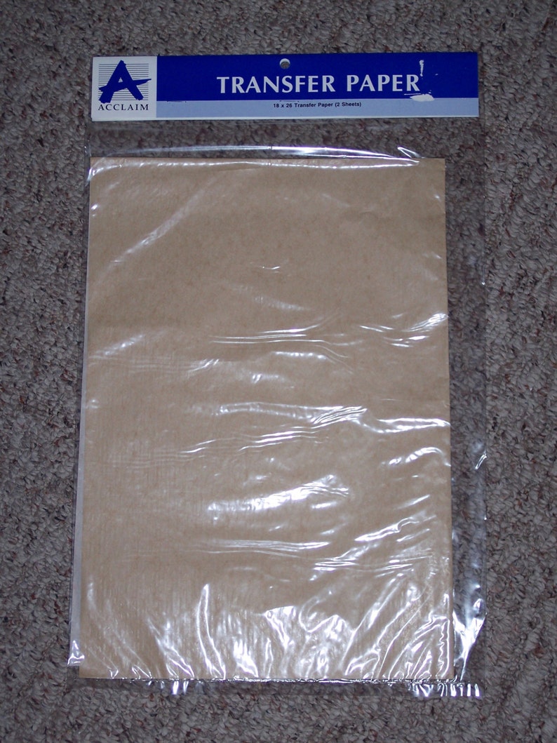 May include: A package of Acclaim brand transfer paper containing two sheets. The packaging features a blue header with the text TRANSFER PAPER and the Acclaim logo. The sheets are light brown and enclosed in a clear plastic sleeve.