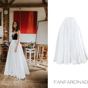 Op de afbeelding: Een witte maxi-rok met een geplooide tailleband. De rok is gemaakt van een lichtgewicht stof en heeft een vloeiende silhouet.