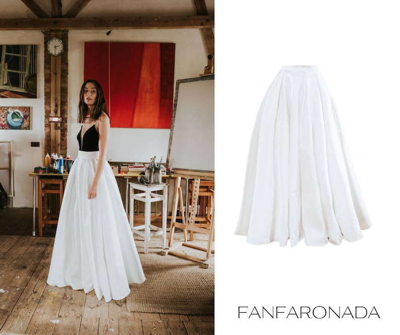 Op de afbeelding: Een witte maxi-rok met een geplooide tailleband. De rok is gemaakt van een lichtgewicht stof en heeft een vloeiende silhouet.