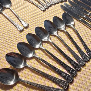 May include: A set of silverware with ornate floral designs. The set includes spoons, forks, and knives.