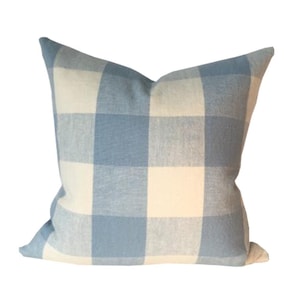 May include: A blue and white gingham pillow cover. The pillow is made of a soft, woven fabric and has a square pattern.