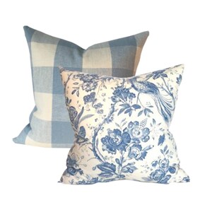 May include: Two decorative throw pillows, one with a blue and white gingham pattern and the other with a white background and a blue floral pattern.