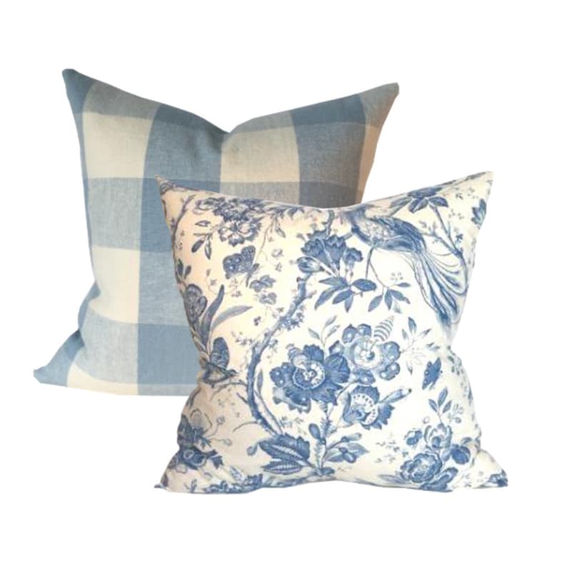 May include: Two decorative throw pillows, one with a blue and white gingham pattern and the other with a white background and a blue floral pattern.