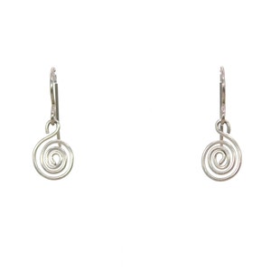 May include: A pair of silver-toned dangle earrings featuring a wire-formed spiral design. Each earring consists of a circular coil suspended from a simple hook wire, showcasing a metallic finish and a clean, symmetrical aesthetic for the set.