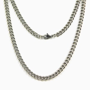 May include: A silver chain necklace with a lobster clasp closure. The chain is made of a curb link design.