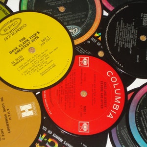 Puede incluir: Una colecci&oacute;n de discos de vinilo vintage con varios artistas y t&iacute;tulos de &aacute;lbumes. Los discos son de diferentes colores, incluyendo rojo, amarillo y negro. Los discos est&aacute;n dispuestos en un patr&oacute;n circular, con las etiquetas hacia arriba.