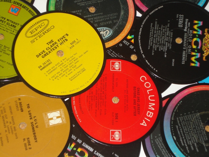 Puede incluir: Una colecci&oacute;n de discos de vinilo vintage con varios artistas y t&iacute;tulos de &aacute;lbumes. Los discos son de diferentes colores, incluyendo rojo, amarillo y negro. Los discos est&aacute;n dispuestos en un patr&oacute;n circular, con las etiquetas hacia arriba.