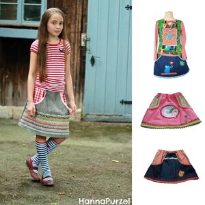 以下が含まれることがあります： 赤と白のストライプのTシャツ、カラフルなトリムが付いたグレーのスカート、ストライプの靴下を履いた若い人。画像には、動物のアップリケが付いた長袖シャツとスカートのセット、ユニコーンが付いたピンクのスカート、デニムスカートの3つの子供服も表示されています。