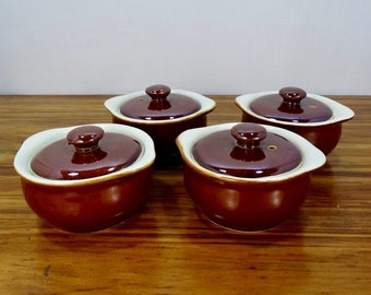May include: Set of four brown ceramic ramekins with white rims and lids. Each lid has a small knob on top.