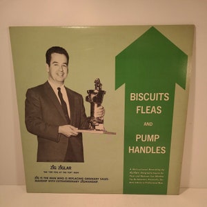 Puede incluir: Una portada de álbum de disco verde y blanca con una foto de un hombre sosteniendo una manivela de bomba. El título del álbum es "Biscuits Fleas and Pump Handles" y el artista es "Zig Ziglar, The "See You at the Top" Man". El texto en la portada del álbum dice "Zig is the man who is replacing ordinary salesmanship with extraordinary Zigmanship."
