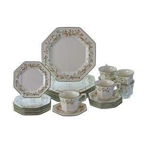 May include: A complete octagonal dinnerware set with a floral design. The set includes plates, saucers, and teacups. The plates and cups have a white background with a green border and a floral pattern in pink and beige.