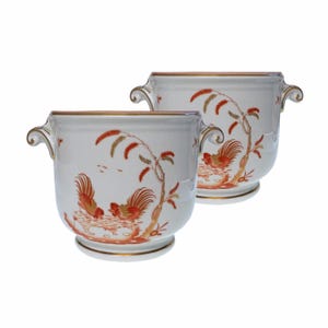 May include: Two white porcelain planters with a rooster and tree design in red and gold. Each planter has a gold rim and handles. The planters are on a white background.