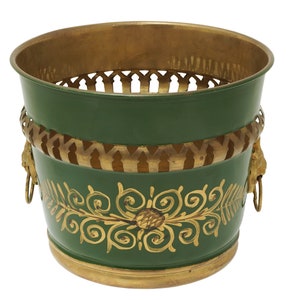 May include: A green metal planter with gold accents. The planter features a gold rim, a decorative band with lion head details, and a gold floral design. The planter is approximately 8 inches in diameter and 7 inches tall.
