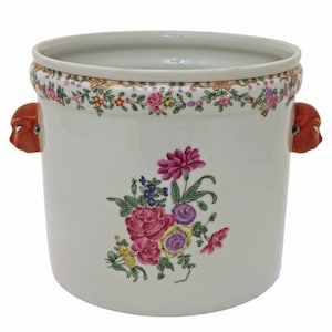 May include: White porcelain planter with floral design and red lion head handles.