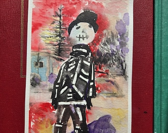 May include: Watercolor painting of a skeleton figure in a black hat and coat, set against a winter landscape with a red and orange sky. The figure has a white face with black details. The artwork is on a white rectangular paper.