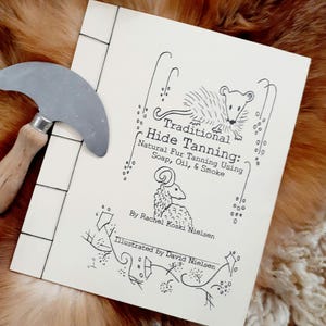 Puede incluir: Un libro blanco con una ilustración en blanco y negro de un animal pequeño en la portada. El título del libro es "Traditional Hide Tanning: Natural Fur Tanning Using Soap, Oil, & Smoke". El libro es de Rachel Koski Nielsen e ilustrado por David Nielsen.