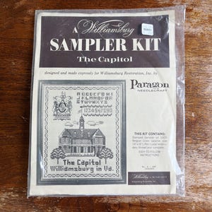 Puede incluir: Un kit de bordado Williamsburg, con el Capitolio de Williamsburg, Virginia. El kit incluye un sampler estampado en lino, hilo de bordar e instrucciones. El diseño incluye el alfabeto, números y una ilustración detallada del edificio del Capitolio.