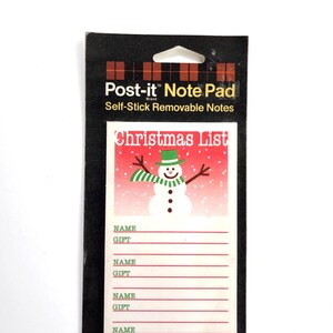 May include: A Post-it Note Pad featuring a Christmas List design with a snowman wearing a green hat and scarf against a red snowy background. The notepad includes printed lines for Name and Gift entries on a white background, packaged on a black card.