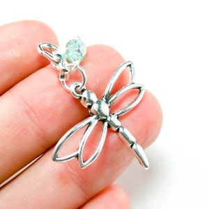 Puede incluir: Encanto de libélula de plata con una cuenta de cristal transparente. La libélula tiene un diseño detallado y es un encanto popular para la elaboración de joyas.