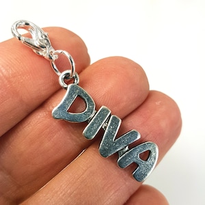 May include: Silver charm with the word "DIVA" in stylized lettering. The charm has a lobster clasp.
