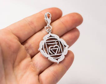 May include: Silver charm with a detailed design of the Anahata chakra, the heart chakra, with a heart symbol in the center.