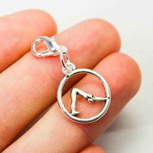 Peut inclure: Breloque en argent avec un design circulaire représentant un nageur en position de plongeon. Le breloque est doté d'un fermoir à ressort.