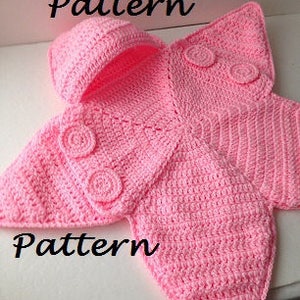 May include: Pink crocheted baby blanket with a hood and a butterfly design. The blanket has three crocheted buttons on each side.
