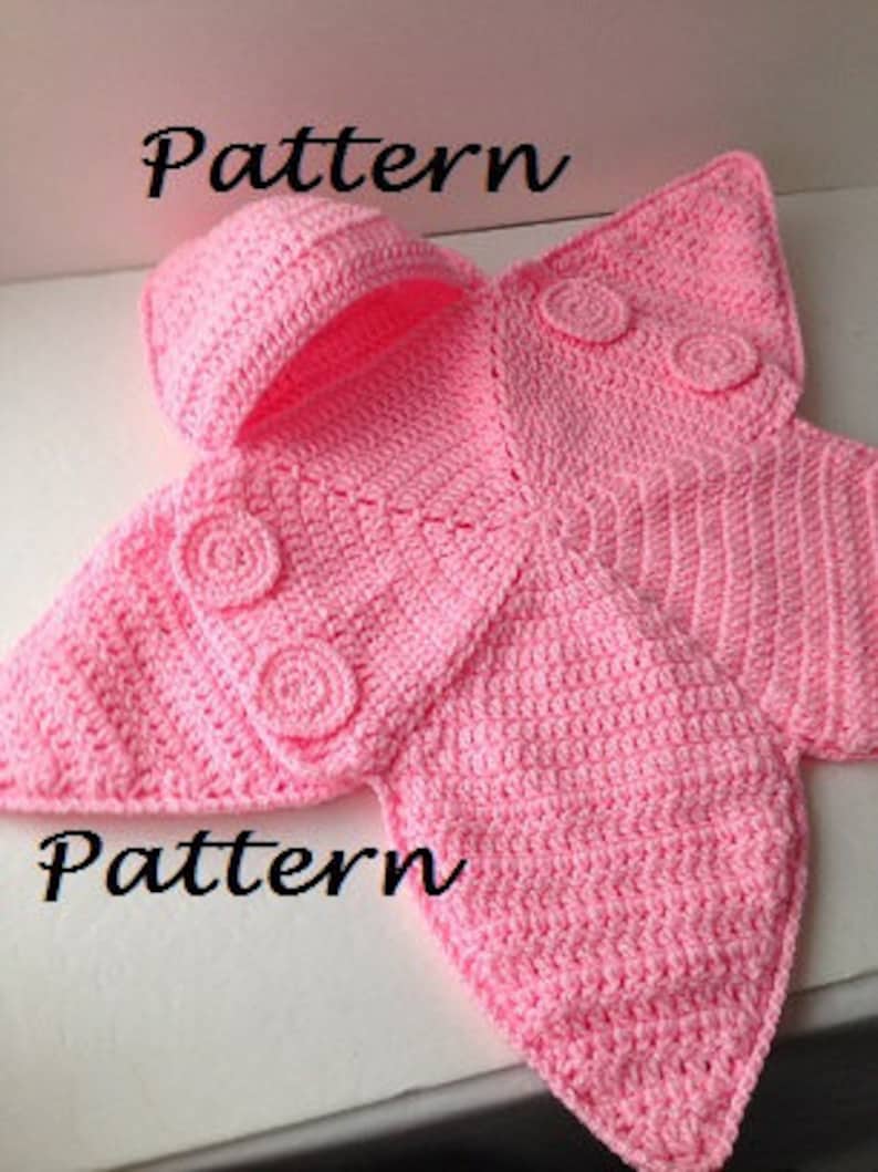 May include: Pink crocheted baby blanket with a hood and a butterfly design. The blanket has three crocheted buttons on each side.