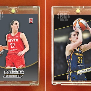 May include: Two Caitlin Clark basketball trading cards in protective cases. One card features Clark in a red Fever uniform, the other in a blue Indiana uniform. Both cards have the text "GENERATION NEXT TRADING CARD". One card reads "ROOKIE OF THE YEAR".