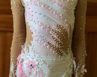 May include: A white and pink leotard with long nude mesh sleeves, embellished with pearls and rhinestones. The leotard features floral accents and a high neckline, designed for rhythmic gymnastics or dance performances.